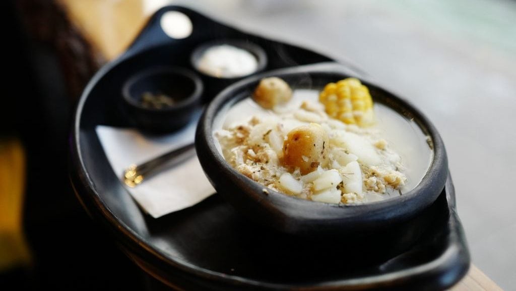 Sopa de ajiaco servida con crema agria y alcaparras como acompañamiento. Comida callejera colombiana en la calle Dupont, presentada en Saturday Living. 27 de noviembre de 2024. (Michelle Mengsu Chang/Getty Images)