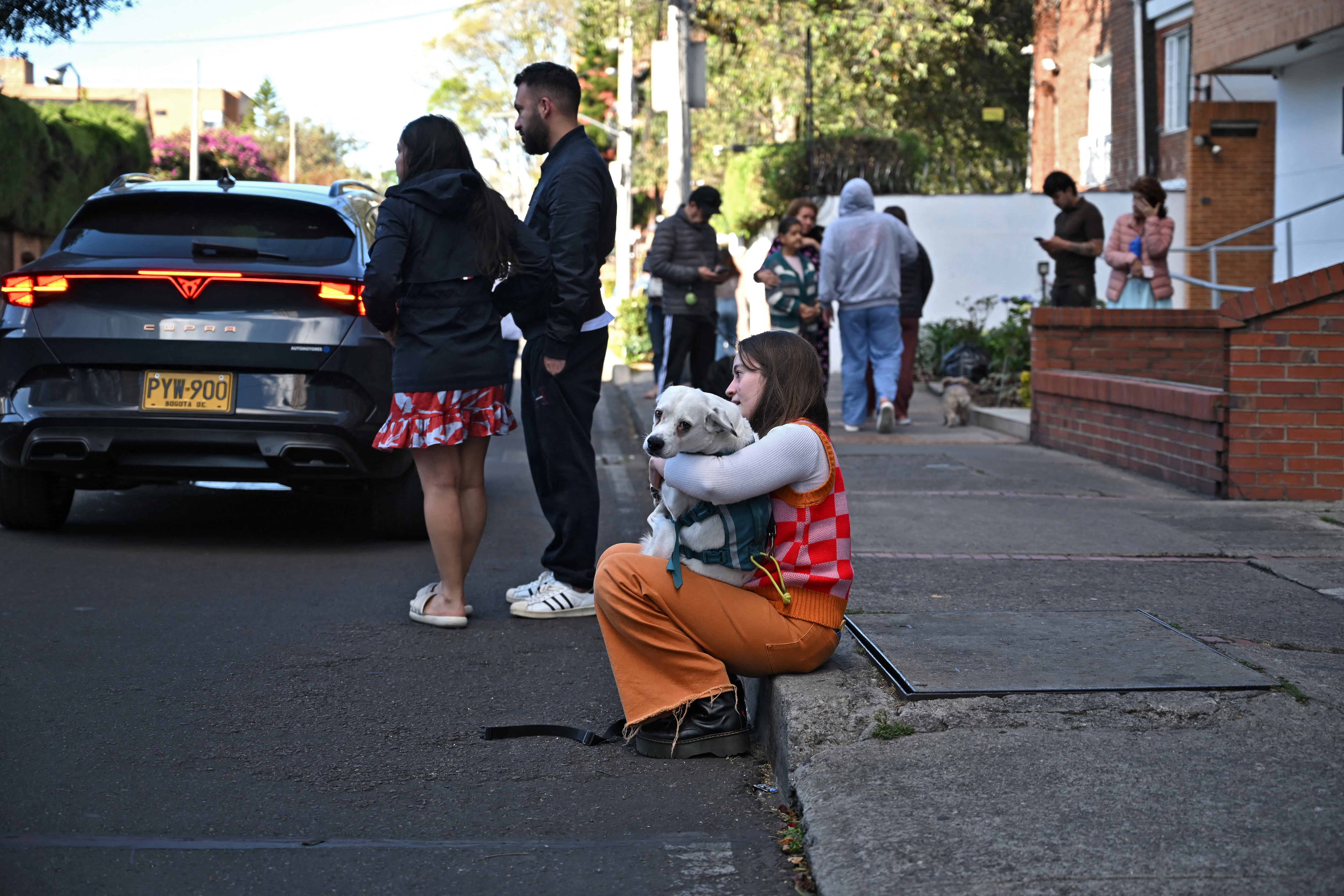 Una mujer carga a su perro en brazos tras el terremoto en Bogotá tras el terremoto de Colombia el 10 de agosto de 2026