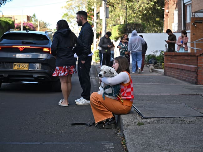 Una mujer carga a su perro en brazos tras el terremoto en Bogotá tras el terremoto de Colombia el 10 de agosto de 2026