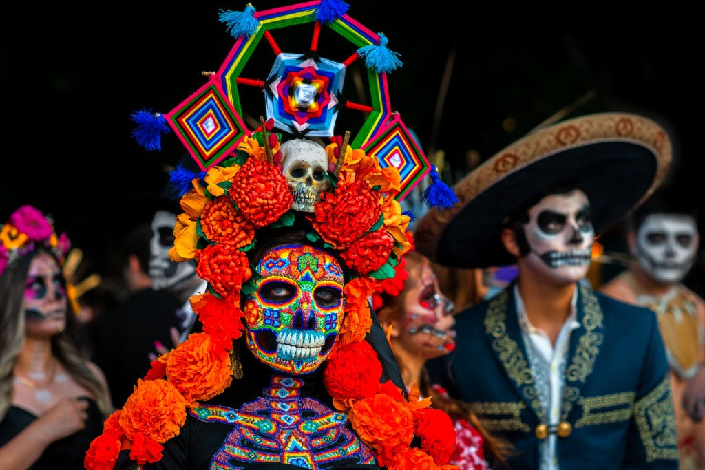 A Mexican woman, dressed as La Catrina and wearing Huichol beaded mask and dress, takes part in the Day of the Dead celebrations on November 1, 2022 in Morelia, Michoacán, Mexico. Day of the Dead. Jan Sochor/Getty Images.