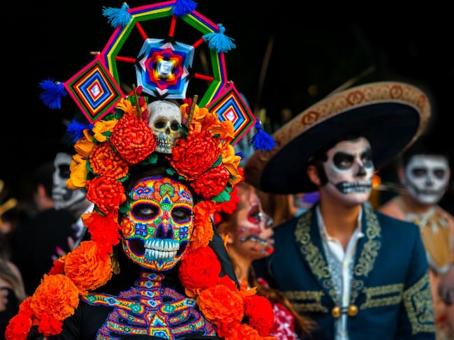 A Mexican woman, dressed as La Catrina and wearing Huichol beaded mask and dress, takes part in the Day of the Dead celebrations on November 1, 2022 in Morelia, Michoacán, Mexico. Day of the Dead. Jan Sochor/Getty Images.