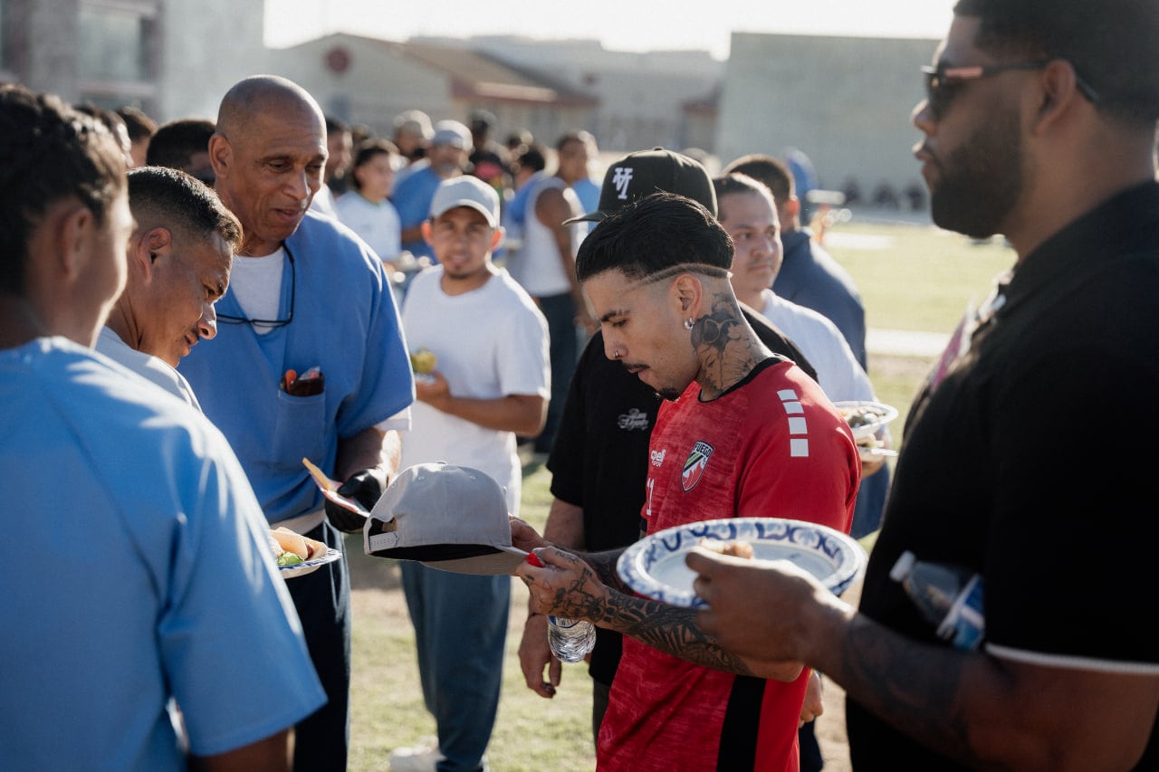 Rauw Alejandro shares a heartfelt moment with incarcerated youth during the “PaMaRa x VSP” event at Valley State Prison in California / via Artist Publicist