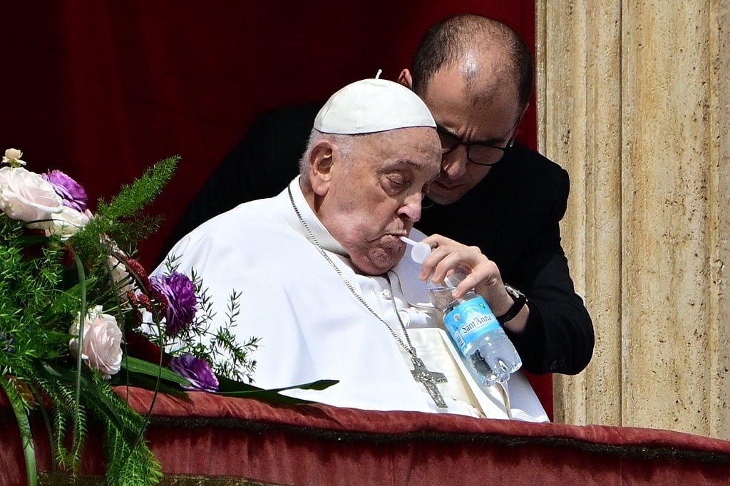 Pope Francis sips water with a straw on the main balcony of St. Peter’s basilica during the Urbi et Orbi message and blessing to the city and the world as part of Easter celebrations, at St Peter’s square in the Vatican on April 20, 2025. Tiziana FABI / AFP) (Photo by TIZIANA FABI/AFP via Getty Images