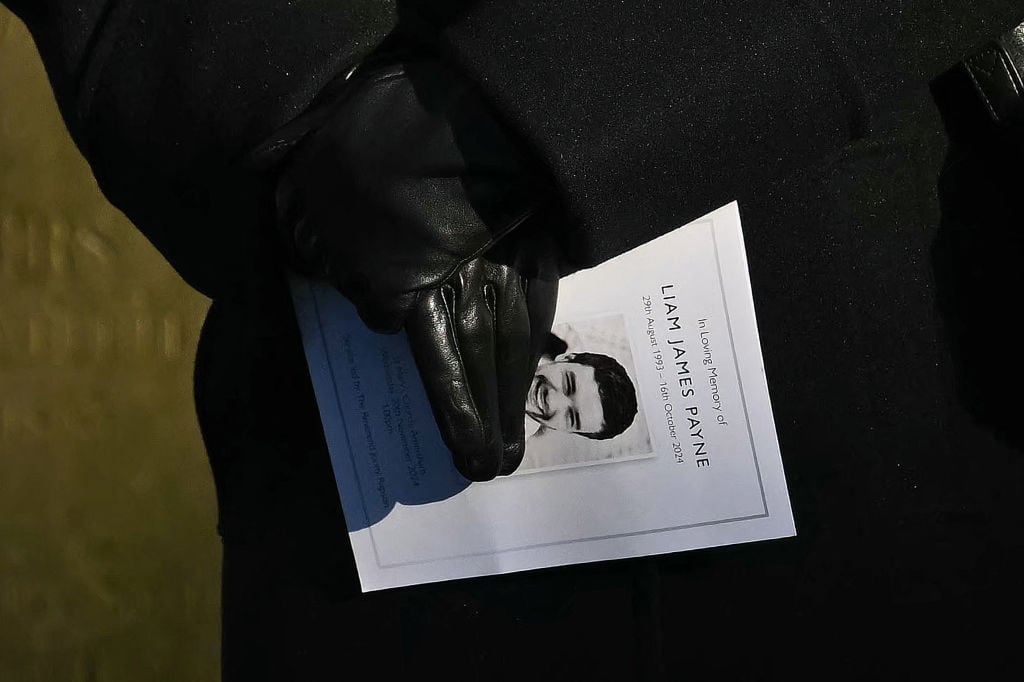 A mourner carries an order of service as they leave after attending the funeral service of the late One Direction singer Liam Payne, at St Mary’s church in Amersham, west of London on November 20, 2024. The funeral of former One Direction singer Liam Payne who died last month after falling from his Buenos Aires hotel room was held on Wednesday. (Photo by JUSTIN TALLIS / AFP) (Photo by JUSTIN TALLIS/AFP via Getty Images)