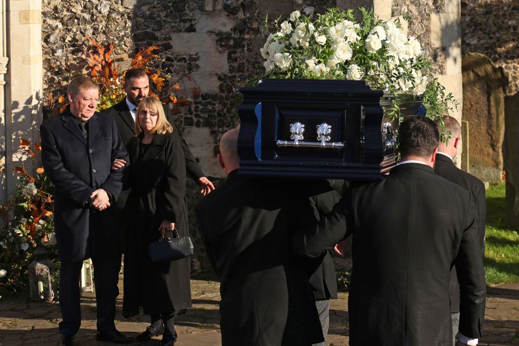 AMERSHAM, ENGLAND – NOVEMBER 20: The parents of Liam Payne, Karen and Geoff Payne, watch as his coffin is carried into the funeral, on November 20, 2024 in Amersham, United Kingdom. Former One Direction star Liam Payne’s private funeral in Amersham has been widely anticipated to draw celebrities and fans alike, wishing to pay their final respects. The singer died after falling from a hotel balcony in Buenos Aires on October 16. (Photo by Dan Kitwood/Getty Images)