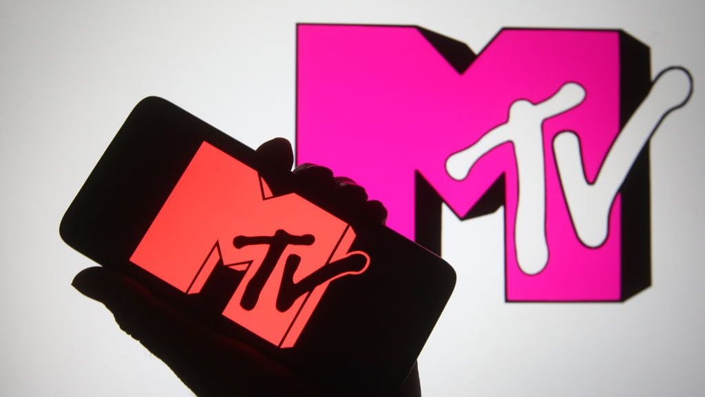 En esta ilustración fotográfica se ve la silueta de una mano sosteniendo un smartphone con el logo del canal MTV en la pantalla. (Pavlo Gonchar/Getty Images)