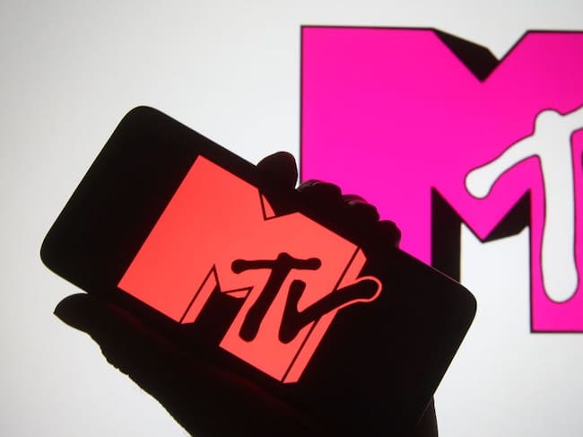 En esta ilustración fotográfica se ve la silueta de una mano sosteniendo un smartphone con el logo del canal MTV en la pantalla. (Pavlo Gonchar/Getty Images)