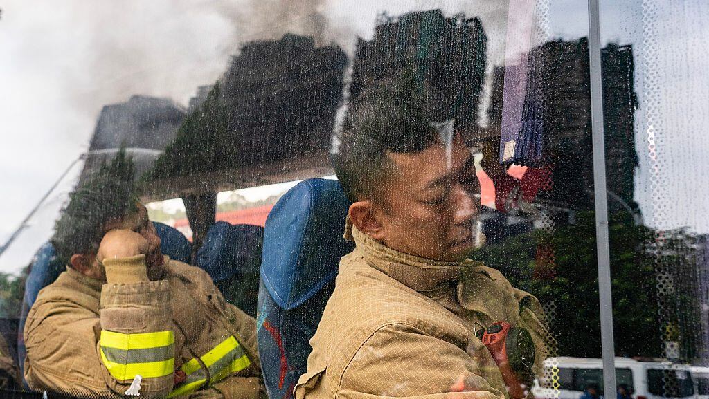 Bomberos rotativos descansan brevemente en el lugar del incendio en el complejo de viviendas Wang Fuk Court en Tai Po el 27 de noviembre de 2025 en Hong Kong, China. (Hou Yu/Getty Images)