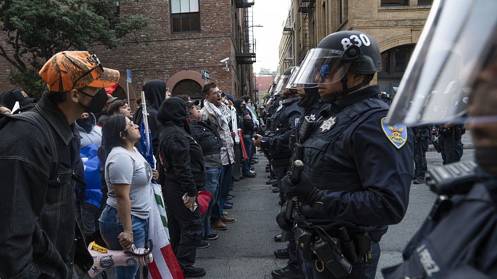 Protestors confront a line of police officers during a rally against ICE's Deportation in San Francisco, United States