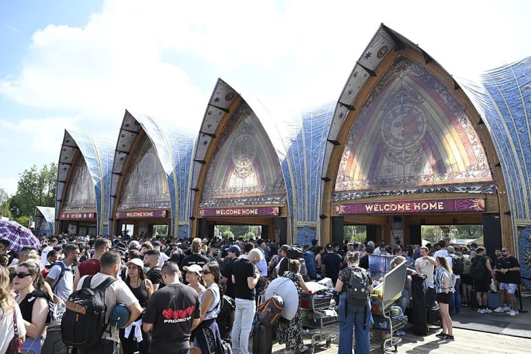 People queue to enter the DreamVille camping site of the Tomorrowland electronic music festival a day after its main stage was totally destroyed by fire