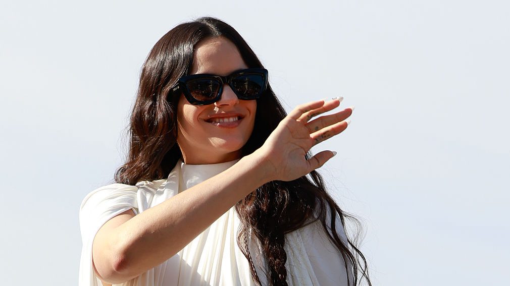 Rosalía es vista usando un mini vestido blanco de gasa con cuello alto, zapatos negros con lazo y gafas de sol negras de Dior afuera de Dior durante la Semana de la Moda de Primavera-Verano 2026 como parte de la Semana de la Moda de París el 01 de octubre de 2025 en París, Francia. (Foto por Hanna Lassen/Getty Images)