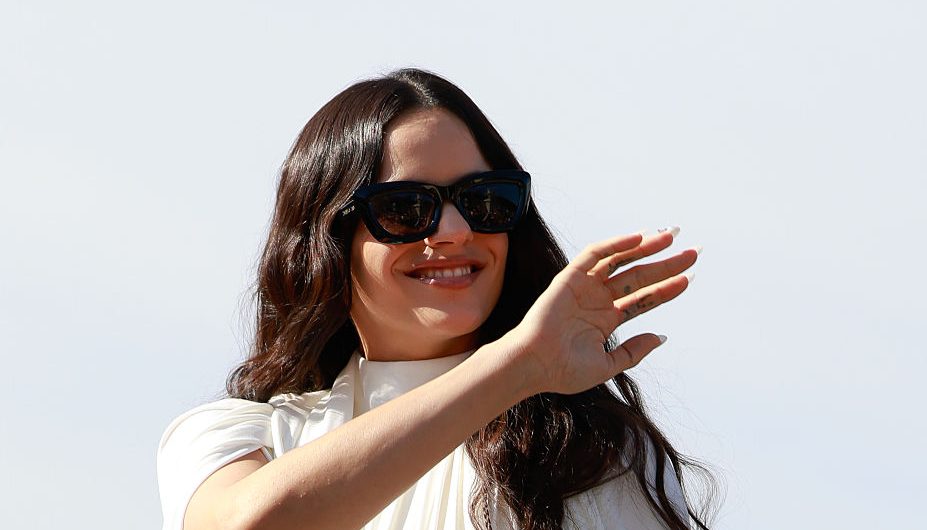 Rosalía is seen wearing white chiffon high-neck mini dress, black bow shoes and Dior black sunglasses outside Dior during the Womenswear Spring Summer 2026